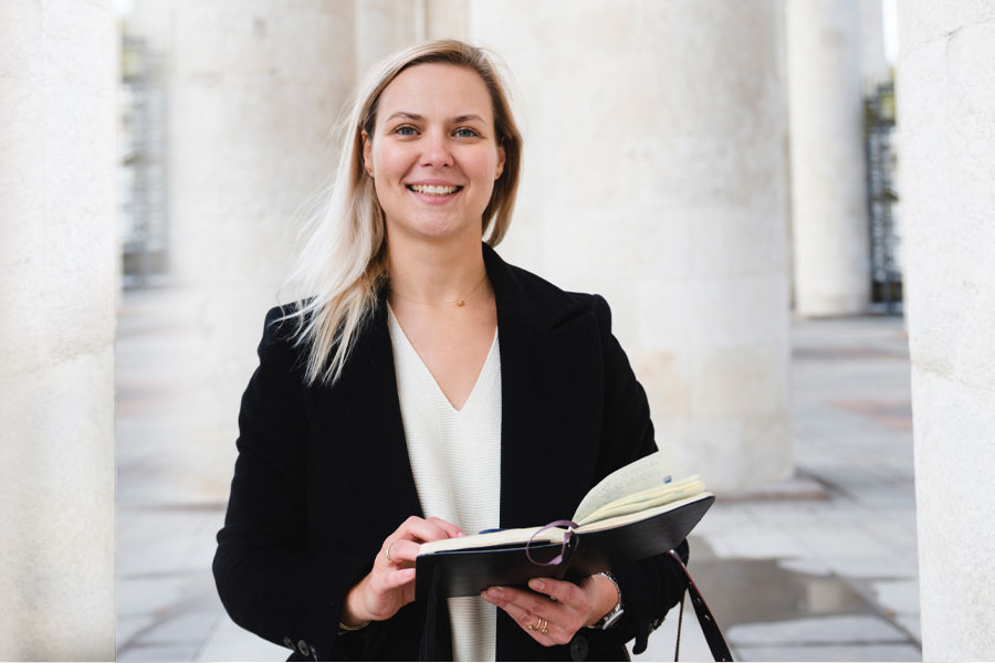 School of Law students smiles for a photo while looking over her notes