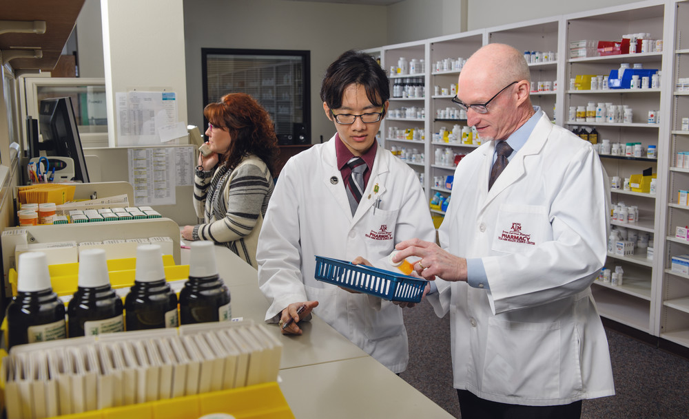 Irma Lerma Rangel School of Pharmacy student checks his work in the clinic with a professor