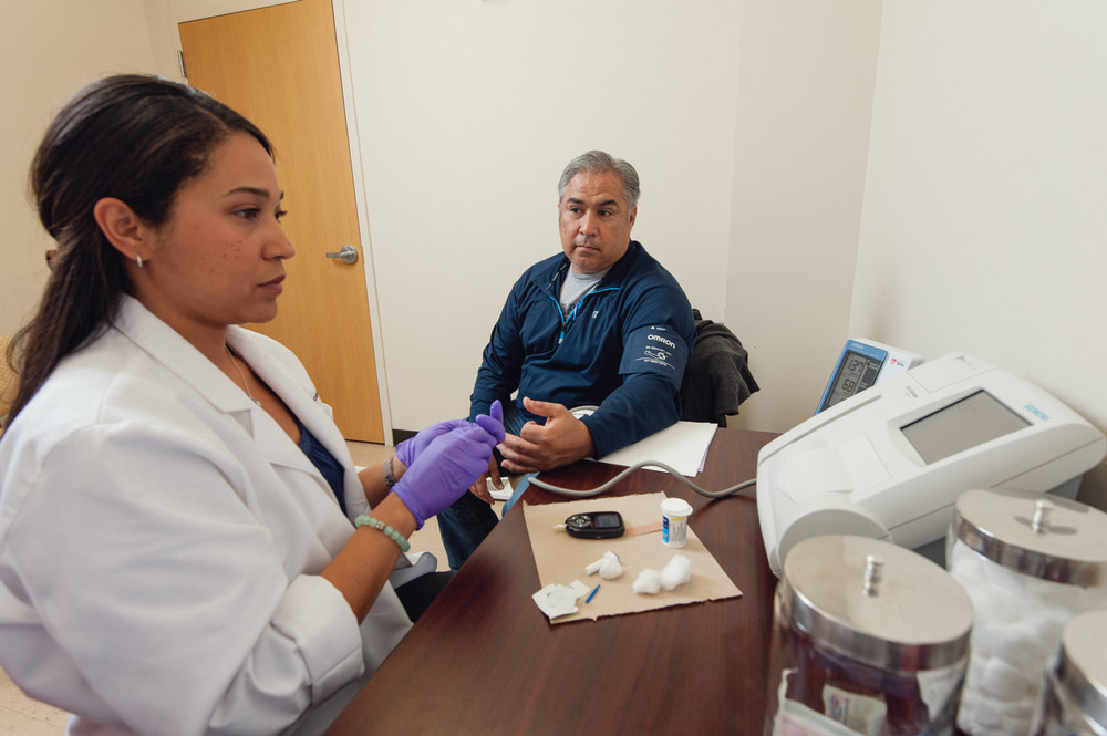 School of Public Health students checks the blood pressure of a patient