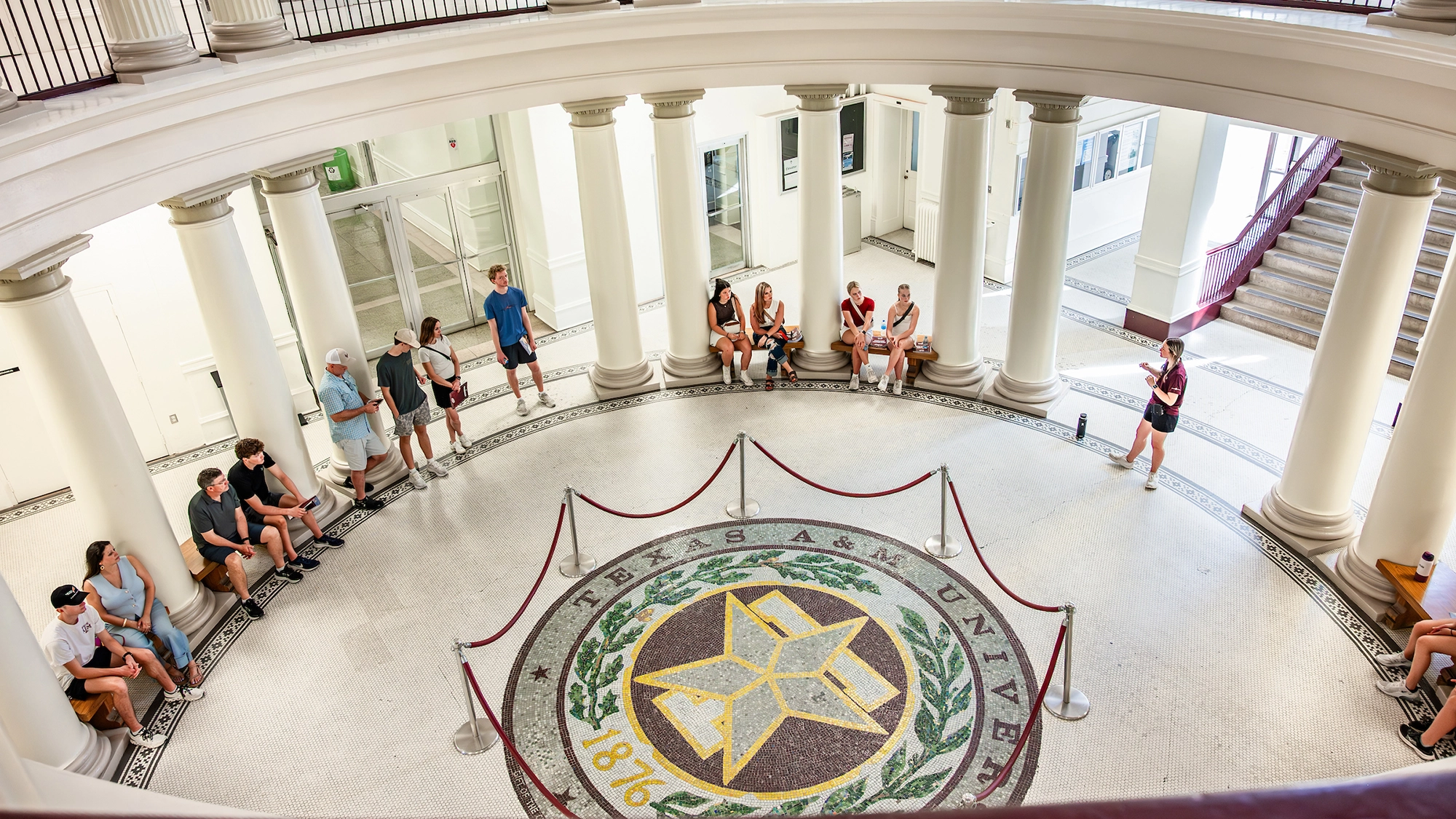 Tour attendees listen to their tour guide in the rotunda of the Academic Building