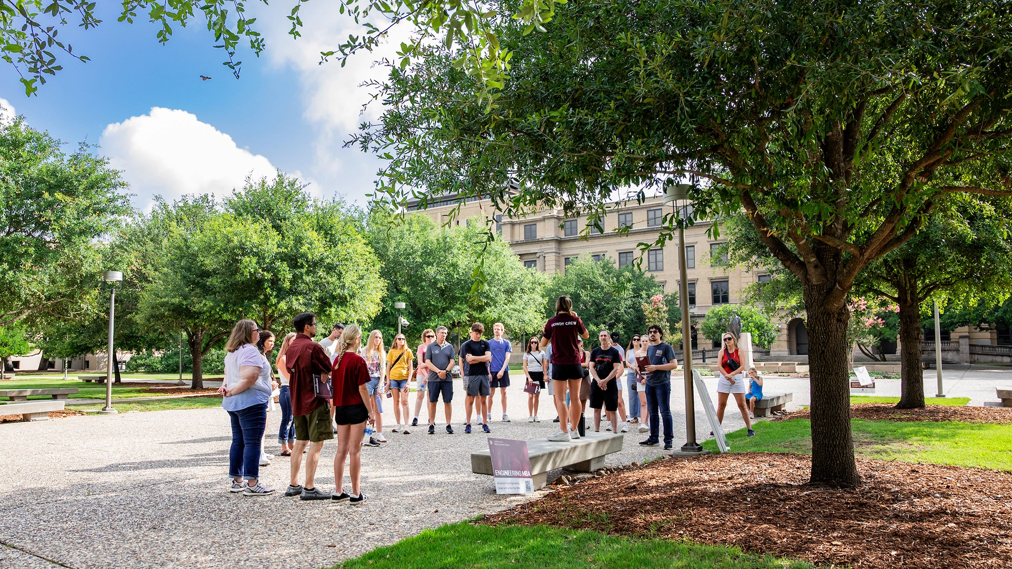 Students listen to their Howdy Crew tour guide at the Academic Plaza