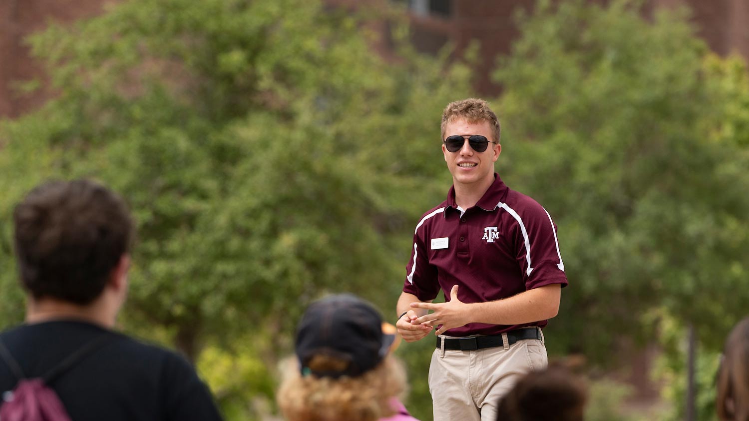 Prospective Texas A&M students listening to a tour group on campus