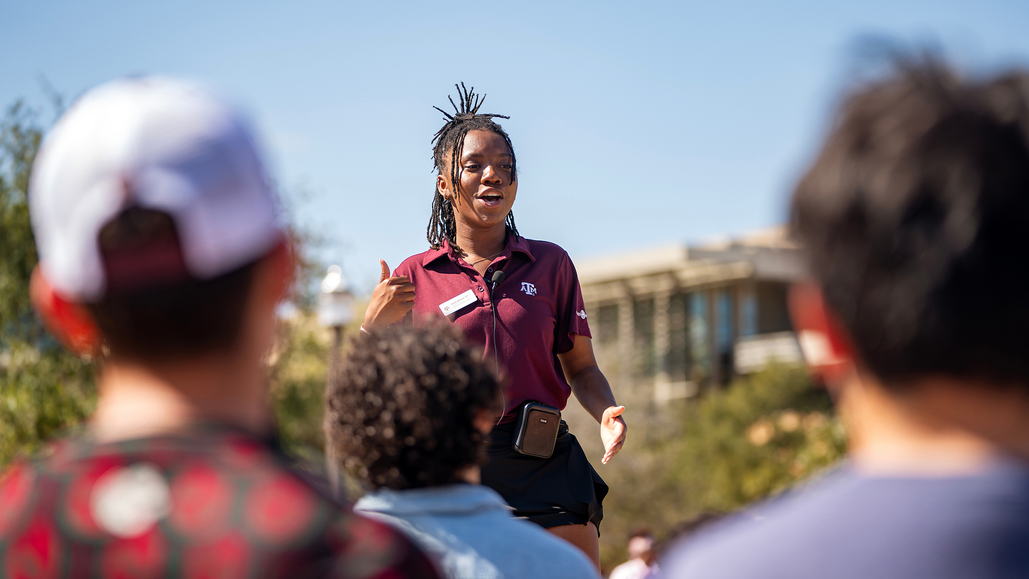 Howdy Crew member gives tour to prospective students from an elevated platform