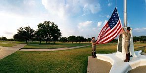 Corps of Cadets members raising an American flag